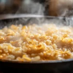 Close-up of pan-fried crispy rice for salad with golden edges and steam